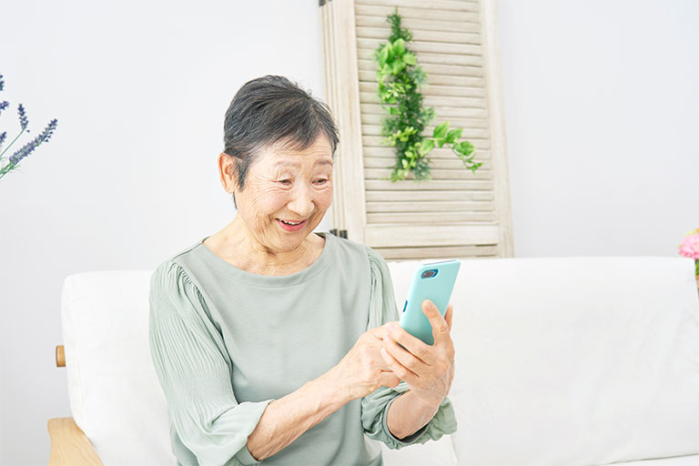 スマホで予約を取る高齢者