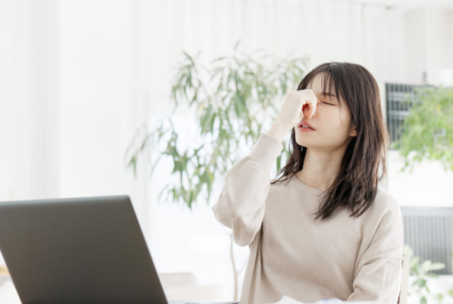 目頭を抑える女性